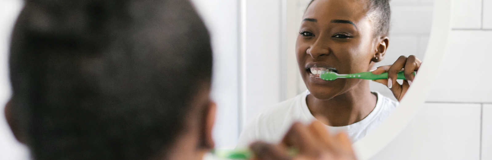 girl-brushing-teeth-in-mirror-1600x522.jpg