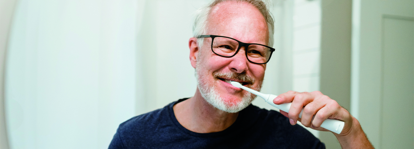 older-man-brushing-teeth-in-mirror-1600x522.jpg