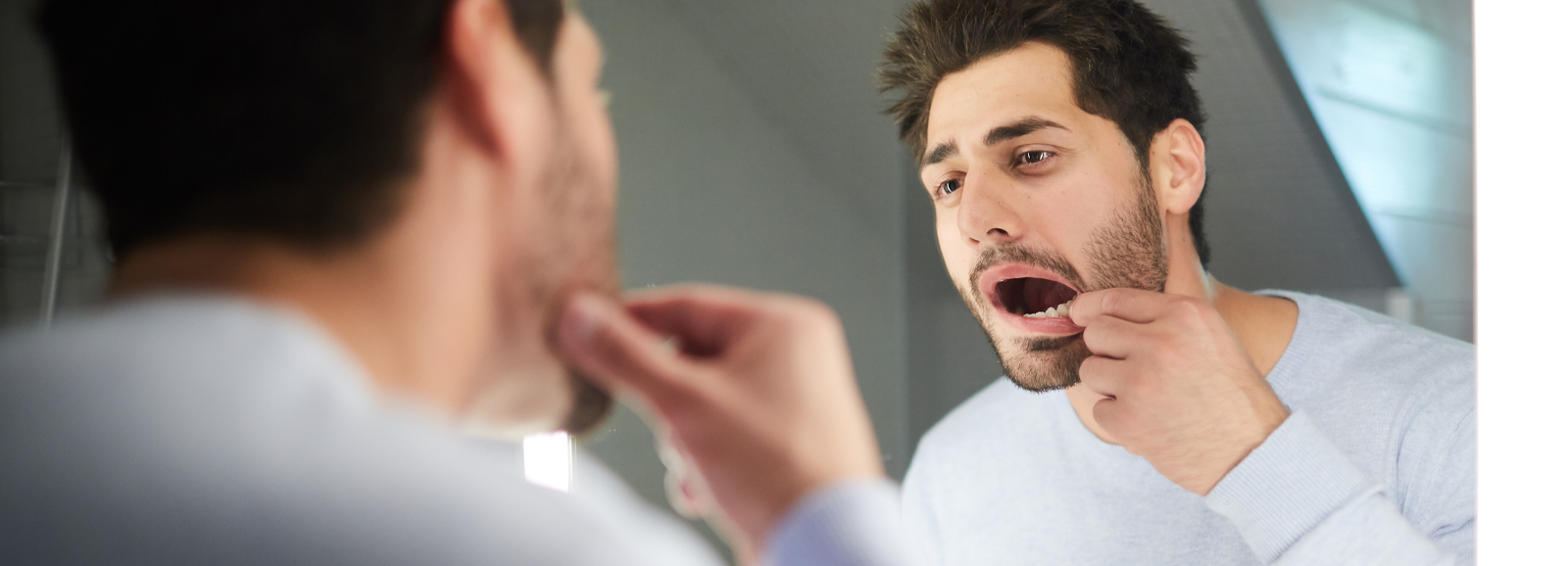 man-looking-at-teeth-1600x578.png
