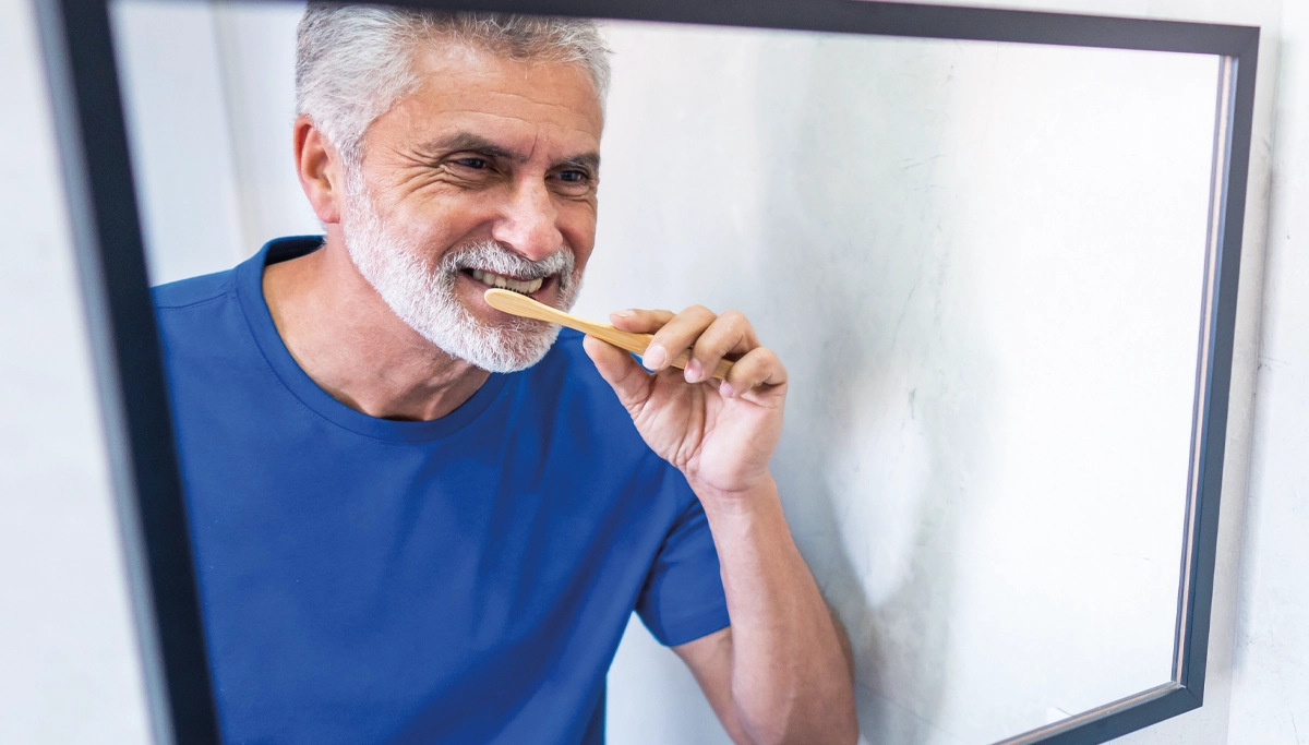 man-brushing-teeth-in-mirror-1200x6831.webp