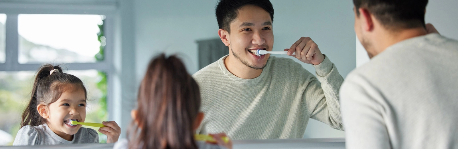 father-and-daughter-brushing-teeth-1600x522.webp