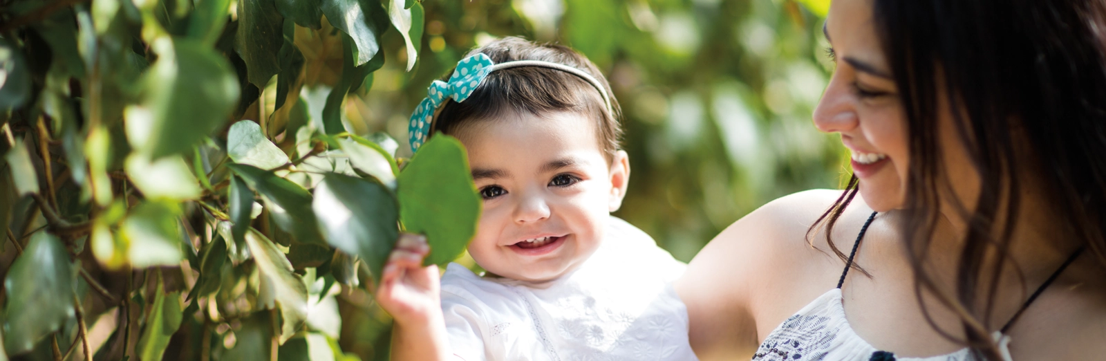 woman-and-baby-smiling-outside-1600x522.webp