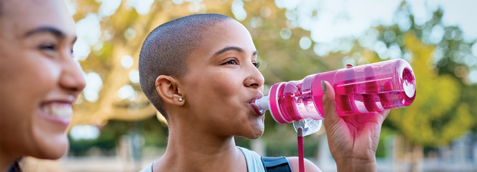 woman-drinking-from-pink-water-bottle-1600x578.webp