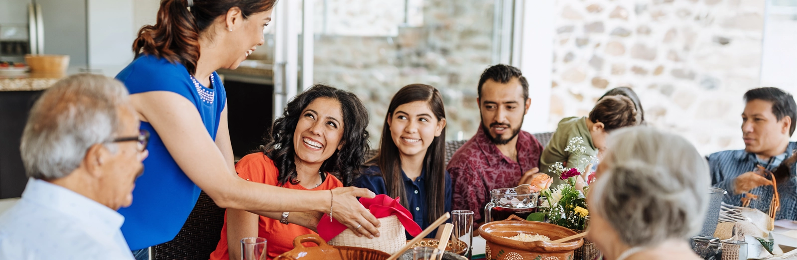 family-smiling-around-thanksgiving-table-1600x522.webp