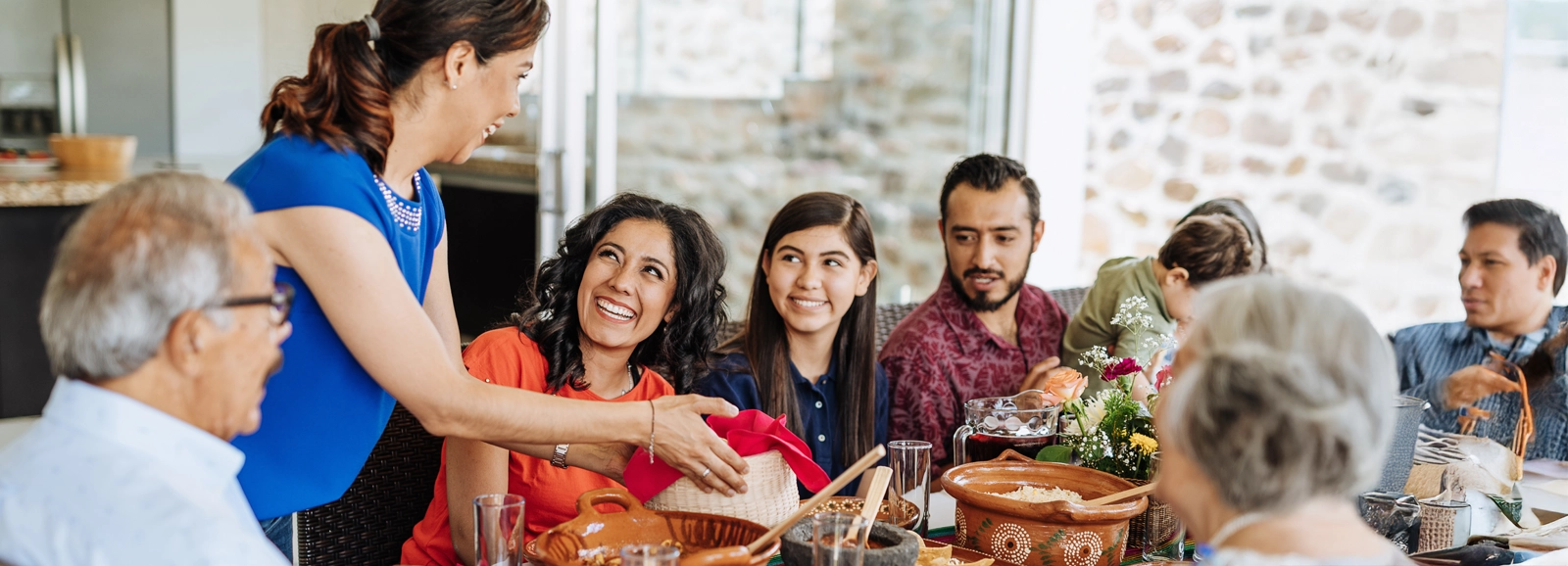 family-smiling-around-thanksgiving-table-1600x578.webp