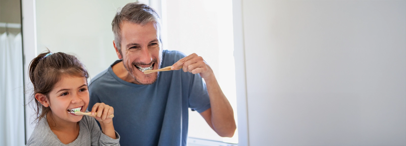 father-and-daughter-brushing-teeth-1600x578.webp