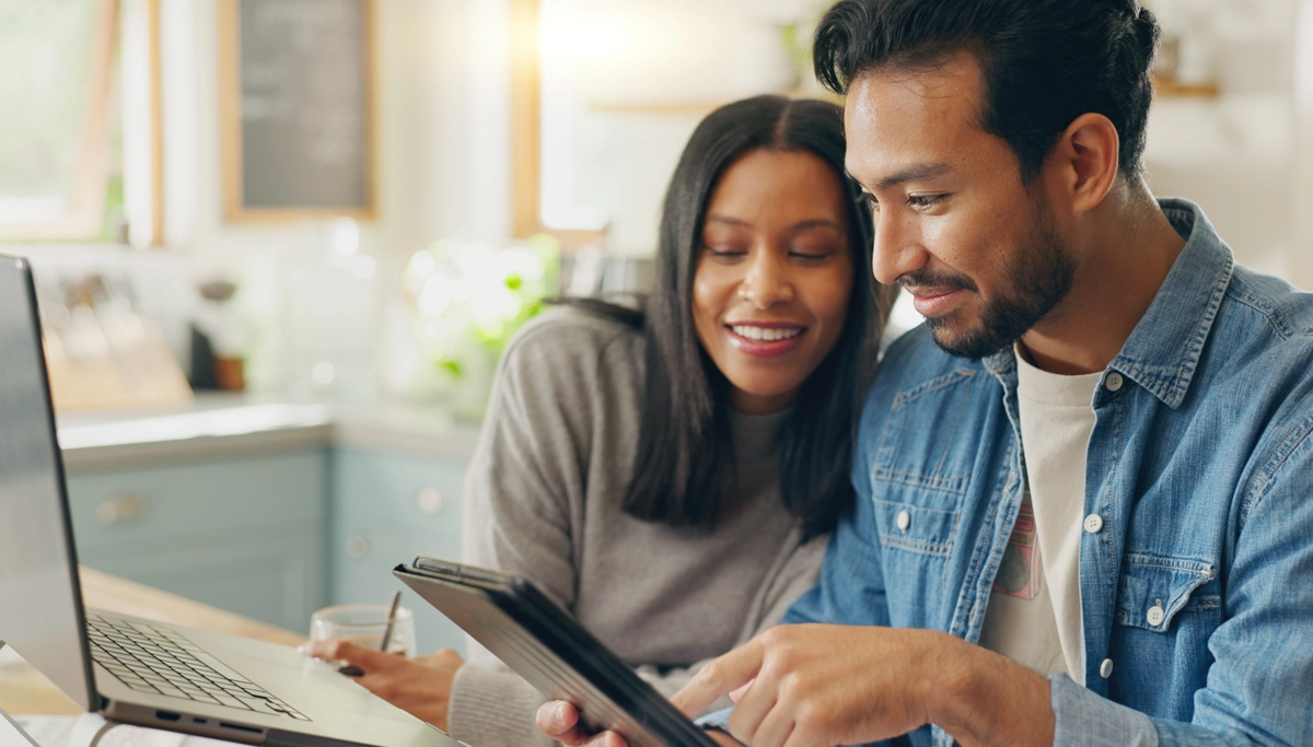 couple-smiling-while-looking-at-tablet-1200x683.webp