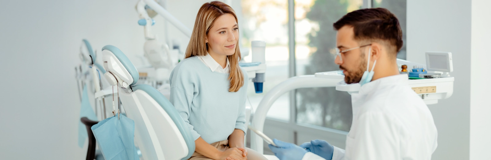 woman-at-dental-office-talking-with-dentist-1600x522.webp