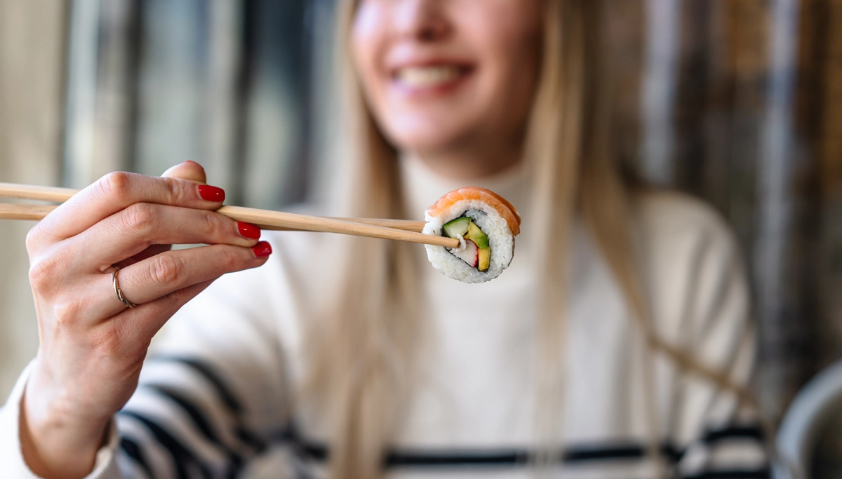 woman-holding-sushi-with-chopsticks-1200x683.webp
