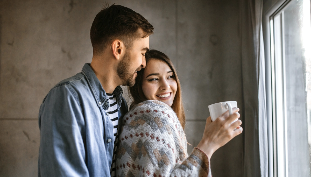couple-smiling-holding-mug-1200x683.webp